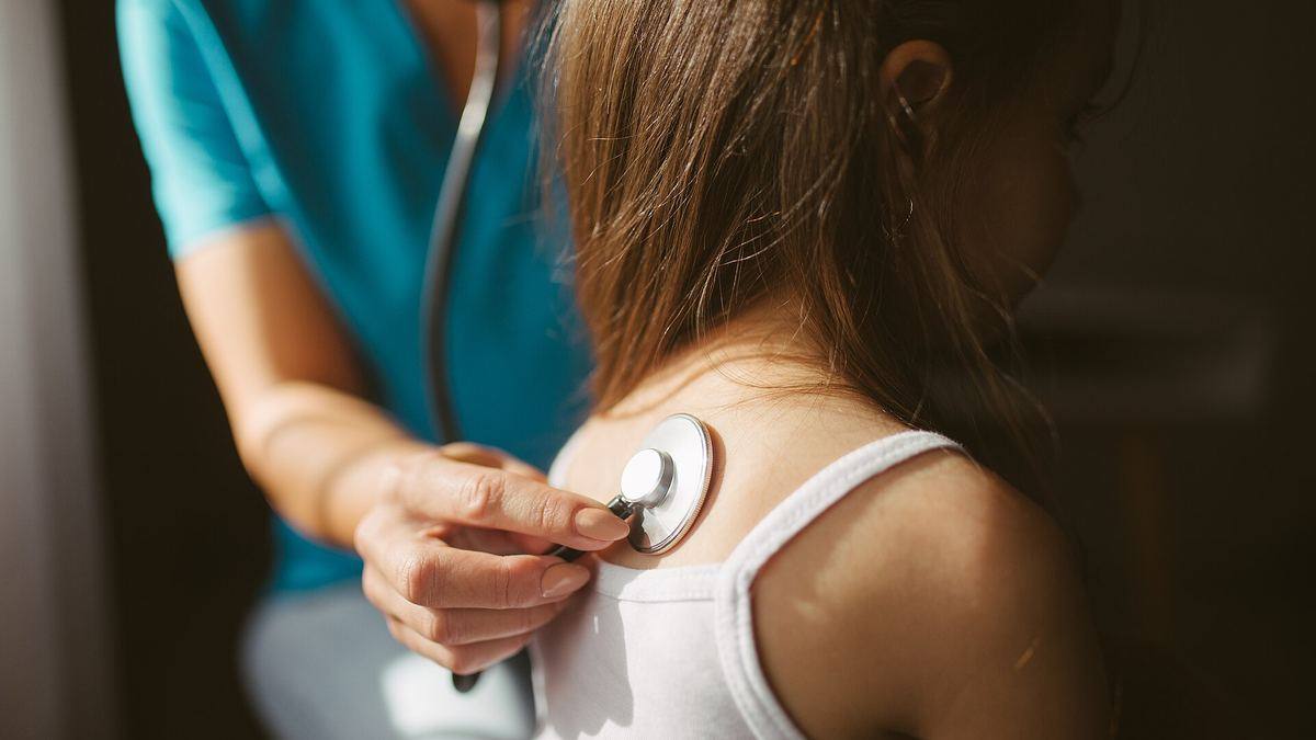 A doctor listening to a patient with a stethoscope